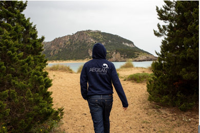 A person walking on a dirt path near a body of waterDescription automatically generated with low confidence